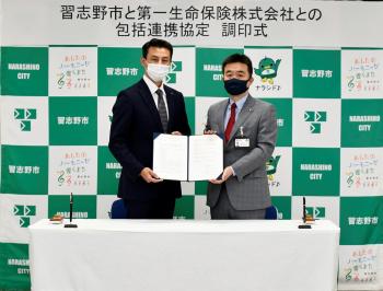 一緒に協定書をもって見せている宮本市長と四方田幕張支社長の写真