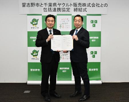 協定書を披露する宮本市長（左）と赤田代表取締役社長（右）