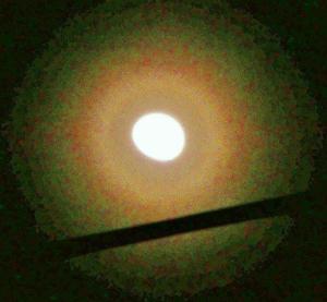月の周りに環のようなものが写っている花粉光環の写真