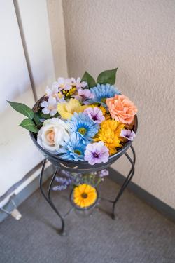 器に青色や黄色やオレンジ色の花を浮かべた花手水の写真