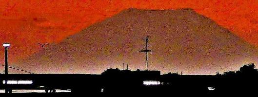赤く染まった空を背景に富士山が写っている写真