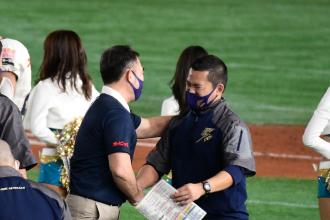 菅原コーチと大橋ヘッドコーチが握手をしている写真