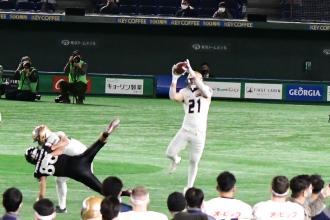 21番の白のユニフォームを着た選手が頭上でボールを受け取った様子の写真
