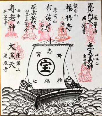 七福神の名前と「宝」と書かれた帆が貼られた船が描かれている色紙の写真