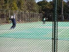 テニスコートで選手がボールを高くあげサーブをしようとしている写真
