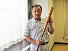 木製のバットを持っている椎名公民館長の写真