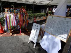 献花会場の看板、宮本市長と清水市議会議長のメッセージボード、千羽鶴が置かれている献花会場入口の写真