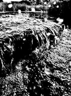 川の水が段差部分を流れ落ちている瞬間を写した白黒写真