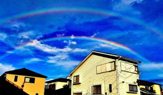 住宅街の空に2重の虹が掛かっている写真