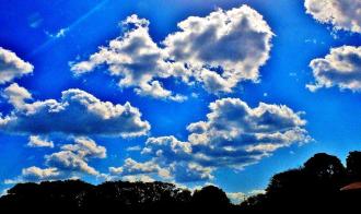 青空に複数の雲の塊が浮かんでいる写真
