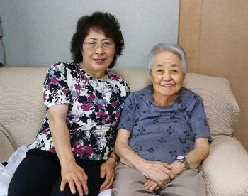 ソファーに並んで座っている海老根 雅子さんと母・高橋 清子さんの写真