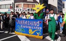 習志野高等学校吹奏楽部の部員が幕をもってパレードをしている写真