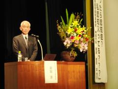 東京大学医学部付属病院神経内科の岩田先生が壇上で話している様子の写真