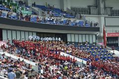 甲子園球場のスタンド席に立っている赤い服を着た習志野高校応援団の写真