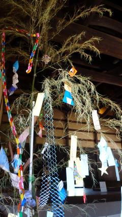 折り紙で作られた様々な飾りや短冊などが飾られた笹竹の七夕飾りの写真