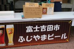 「富士吉田市 ふじやまビール」と書かれた看板が机に取り付けられている写真