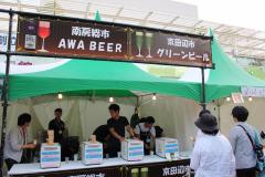 AWABEERやグリーンビールと書かれた看板の下で様々な種類のビールを販売している出店の写真