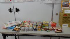 机の上に並べられた袋や缶に入ったいろいろな種類のストック食品の写真