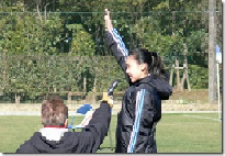 右手を上げ選手宣誓をしている斎藤さんとその横でマイクを持っている人を横から写した写真