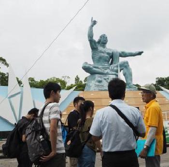 平和祈念像前で説明を受けている平和市民代表団の方の写真
