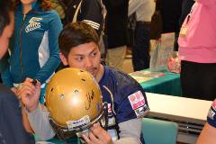 ヘルメットにサインをする砂川選手の写真