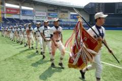 準優勝旗を持つ選手を先頭に1列に並んでグラウンド内を行進する習志野高校の選手たちの写真