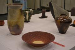 茶色の丸皿、線の模様の入った花瓶の写真