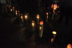 暗い中、並べられた竹灯籠がぼんやりと光っている写真