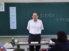 講師の長沢成次さんが黒板の前に立ち、話をしている様子の写真