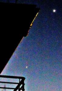 夜空のビルの上空に見える小さく光る木星と金星の写真