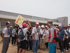 ピンク色の帽子を被った方が旗を手に参加者たちを誘導している写真