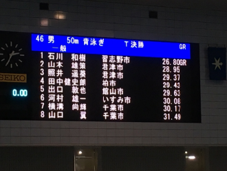 男50メートル背泳ぎ 決勝での1位から8位までの選手の名前が表示されている電光掲示板の写真
