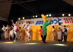 祭りのステージに各チーム代表が踊りを披露している写真