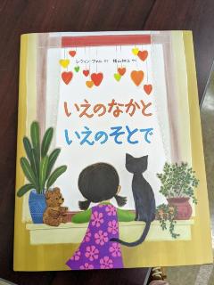 黒猫と女の子の後ろ姿が描かれた「いえのなかと いえのそとで」の本の表紙を写した写真