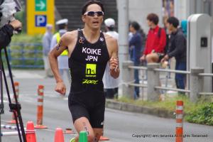 懸命に走る小池選手と沿道で選手を見守る人たちの写真