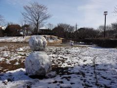 雪の残っている屋敷近隣公園に雪だるまが置かれている写真