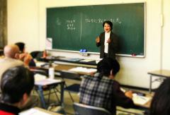 黒板の前に立っている男性が話しをしている日本語ボランティア養成講座の様子の写真