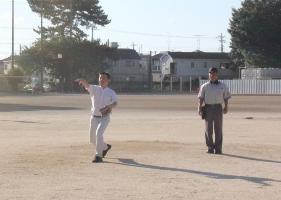 広いグラウンドで始球式を行っている宮本市長の写真