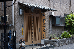 玄関横に「阿武松部屋」と書かれた縦長の看板が掛けられているおおのまつべや玄関前の写真