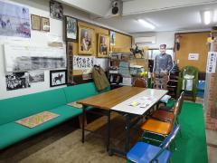 壁に額に入った写真や資料が展示され中央にはテーブルや椅子が置かれている秋山好古大将の資料展示スペースの写真