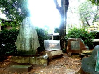 日本大学構内に形の違う石碑が3つ並び、太陽の光が差している写真
