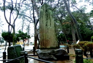 八幡公園内に植えられた木々の中心に紀習志野騎兵旅団発祥の地碑が建てられた写真