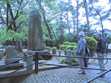 大きな岩の石碑がたっており、2人の男性が石碑を見ている習志野騎兵旅団発祥の地碑の写真