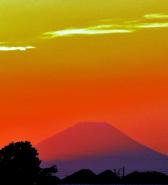 黄色とオレンジ色のグラデーションが美しい空に鷺沼陸橋から見える富士山の影が写っている写真
