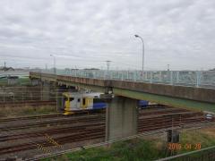 跨線橋の下を電車が通過している写真