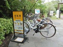 駐輪場の看板が設置され、自転車が並んで置かれている谷津干潟公園東門駐輪場の写真