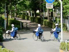 ヘルメットを被り自転車に乗っている3名の女子中学生の写真