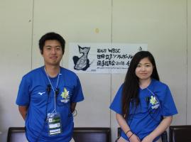 青いTシャツを着た男性と女性のボランティア事務局スタッフが並んで写っている写真