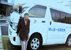 ゆいまーる習志野と車体の横にかかれている車と、その前にいるボランティアグループの赤平さんの写真