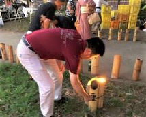 宮本市長が竹灯籠に火を灯している様子の写真